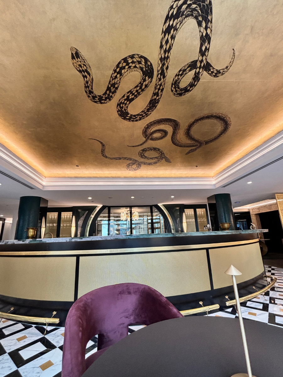 Main bar with hand-painted ceiling artwork and brass-fronted counter