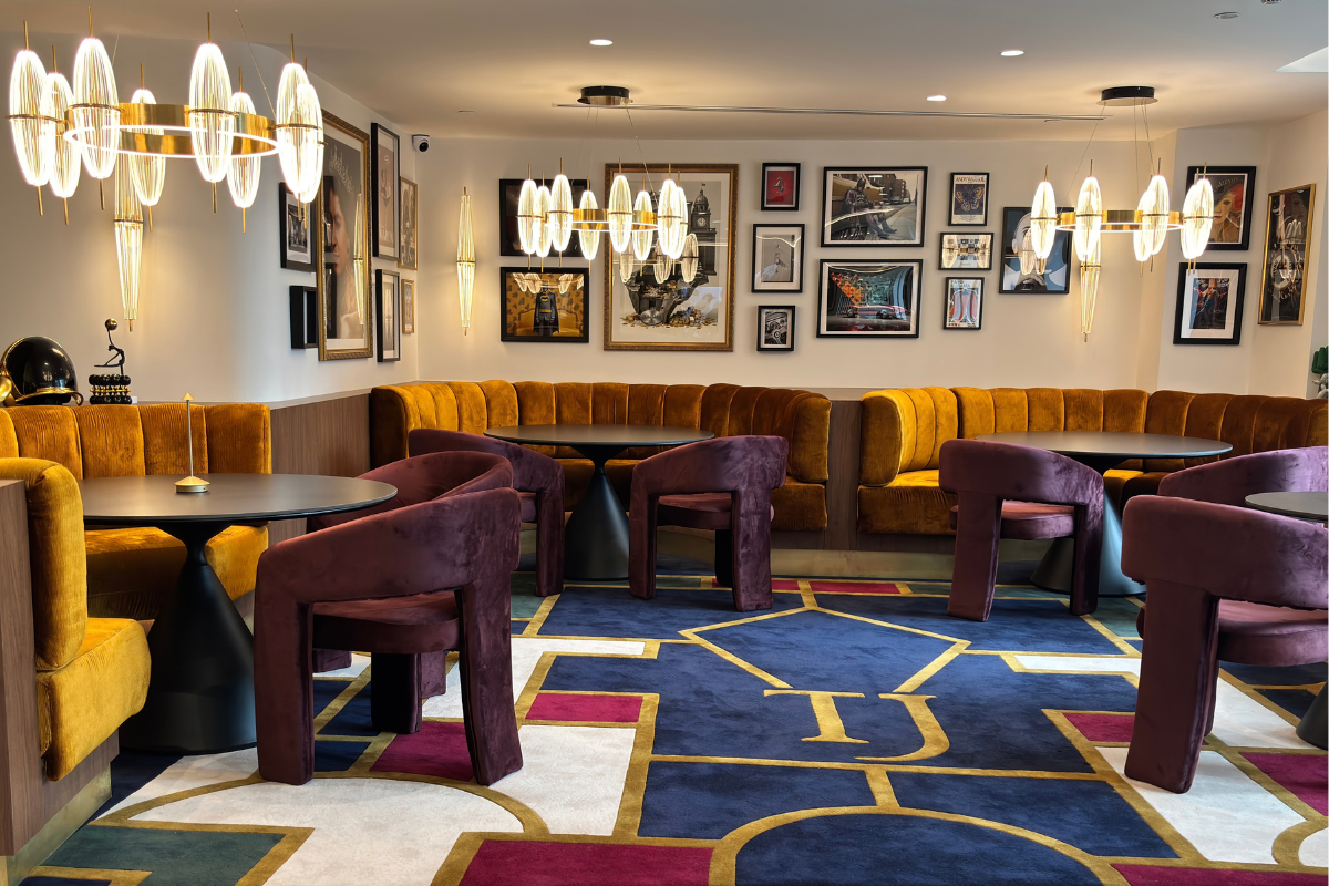 Members lounge dining area with velvet banquettes, pendant lights and a gallery wall